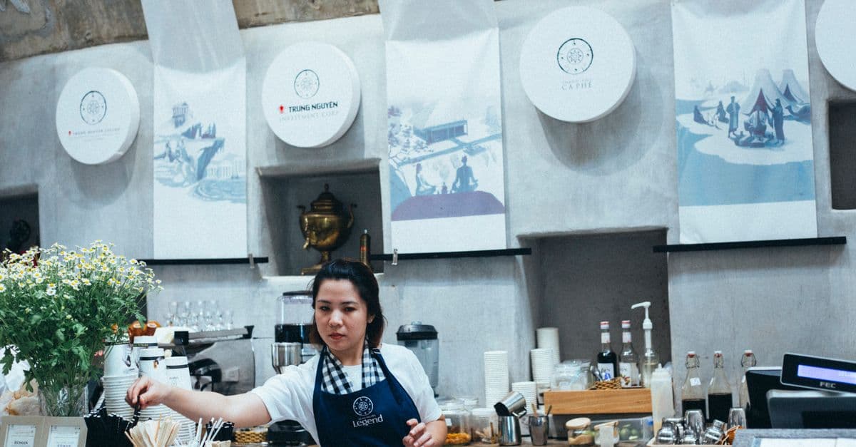 A barista serving in a busy coffee shop