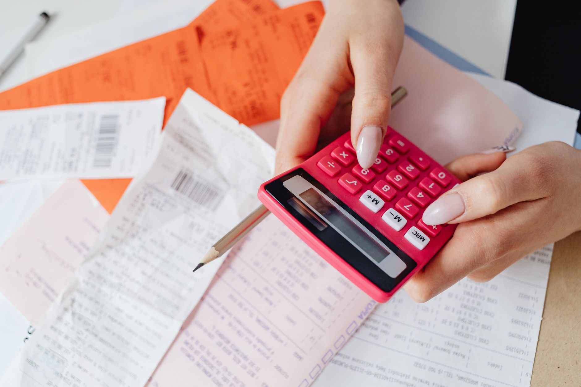 A calculator being used next to paperwork