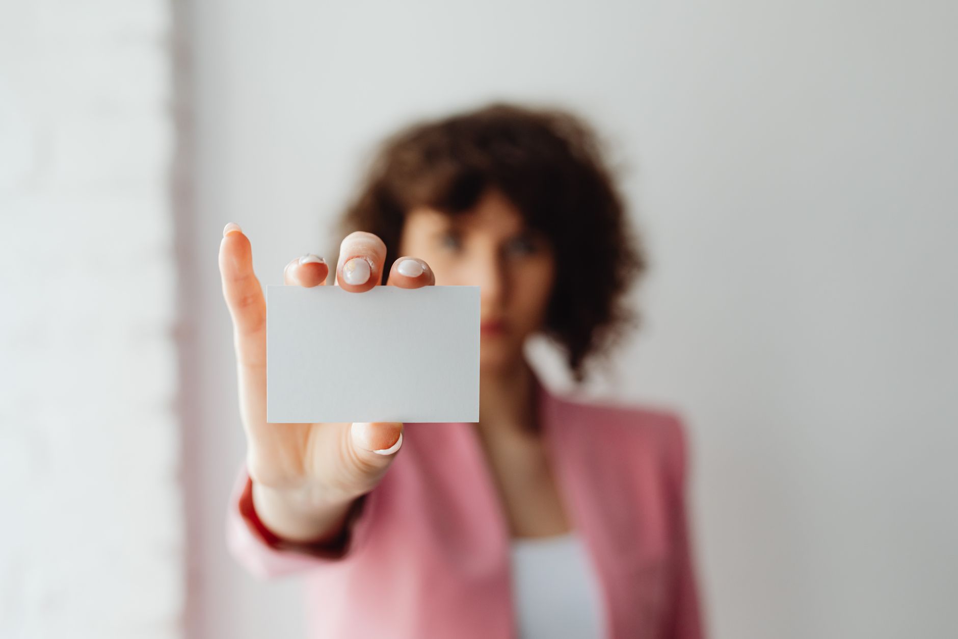 A person handing over a contact card